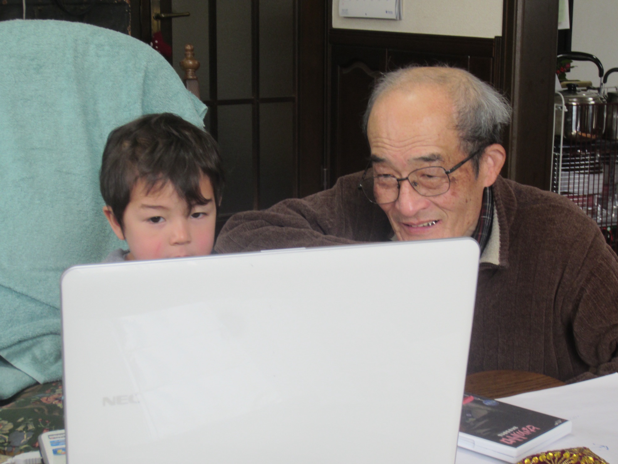 Kai and Jiji looking at a laptop together